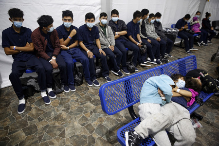 Young unaccompanied migrants, wait for their turn at the secondary processing station in the Department of Homeland Security holding facility on March 30, 2021 in Donna, Texas. The Donna location is the main detention center for unaccompanied children coming across the U.S. border in the Rio Grande Valley. It is an overcrowded tent structure where more than 4,000 kids and families are kept in pods, with the youngest kept in a large play pen with mats on the floor for sleeping. 