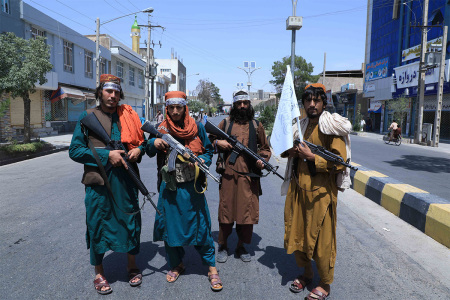 Taliban fighters stand guard along a road near the site of an Ashura procession which is held to mark the death of Imam Hussein, the grandson of the Islamic prophet Mohammad, along a road in Herat on August 19, 2021, amid the Taliban's military takeover of Afghanistan. 