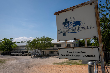 A sign stands outside the Christian Aid Ministries in Titanyen, Haiti, on October 22, 2021. The leader of a Haitian gang who kidnapped a group of North Americans over the weekend has threatened to execute them, according to video seen by AFP. The footage shot October 20, 2021, but released Thursday on social media showed Wilson Joseph, wearing a suit and surrounded by armed men, in front of coffins containing the bodies of five members of his gang. 