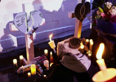 People light candles at a makeshift memorial during a candlelight vigil in Cutler Park in Waukesha, Wisconsin on Nov. 22, 2021, the day after a vehicle drove through a Christmas parade killing five people. 