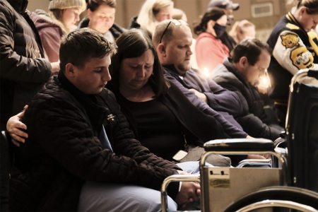 A young man who was reportedly wounded during the shooting at Oxford High School joins other community members during a vigil at the Lake Point Community Church on November 30, 2021, in Oxford, Michigan. Three people were killed and eight others wounded by the alleged shooter, a 15-year-old student who is now in police custody. 