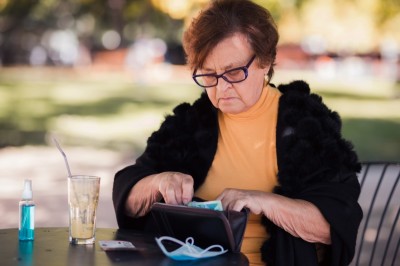 Old woman taking money out of her wallet 