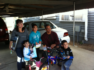 The boy, who chose to give his sisters new bikes instead of himself with his raffle wins, receives his own bike from Pastor Miles McPherson from Rock Church in San Diego, California. 