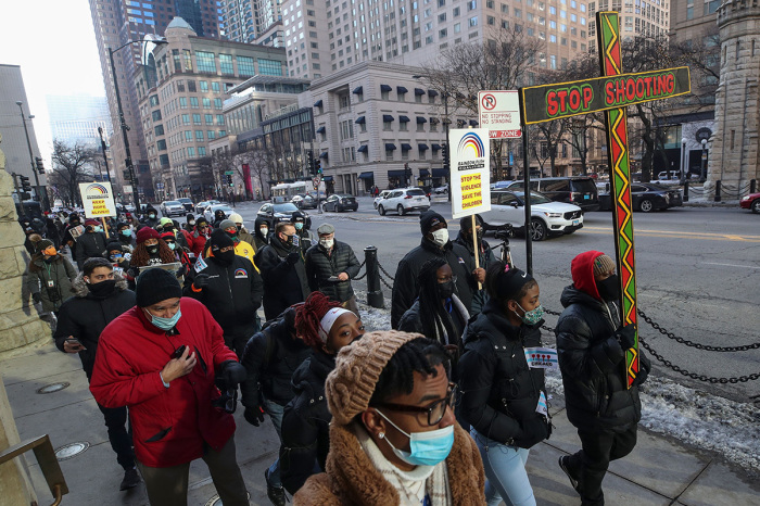 People walk during an anti-gun violence march on the Magnificent Mile in Chicago, Illinois, on December 31, 2020. - In Chicago, murders for 2020 through Dec. 27 stood at 768, up a whopping 252 from the 2019 total of the 516. 