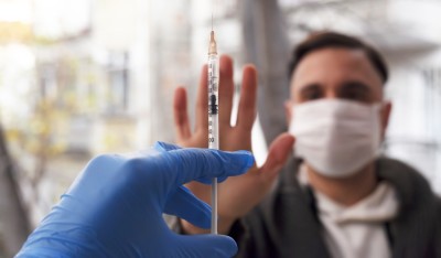 Man refusing to get injection of vaccine for coronavirus. 