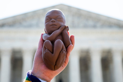 A pro-life demonstrators holds up a model of an unborn baby as she awaits a ruling on abortion in front of the U.S. Supreme Court in Washington, D.C., on June 22, 2020. 