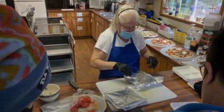 A volunteer helps to give food to the needy at St. Timothy's Episcopal Church of Brookings, Oregon. In January 2022, the church and its diocese filed suit against Brookings city officials over an ordinance restricting their homeless ministry. 