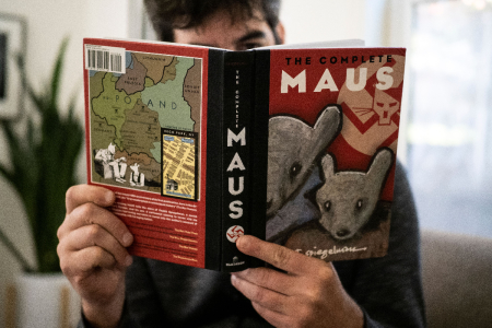 This illustration photo taken in Los Angeles, California on January 27, 2022, shows a person holding the graphic novel 'Maus' by Art Spiegelman. 