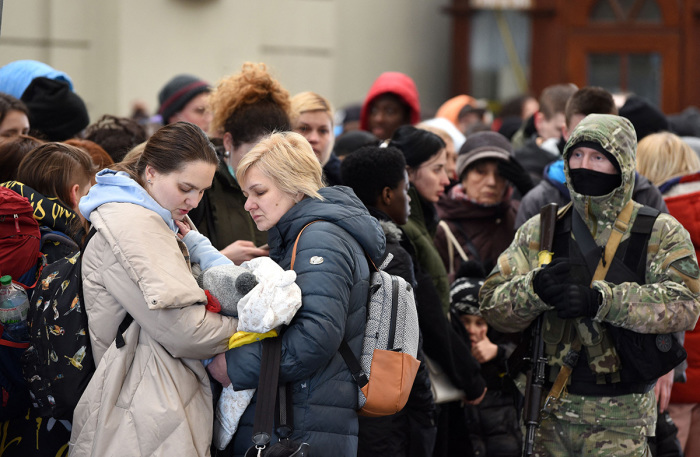 People wait for a train to Poland at the railway station of the western Ukrainian city of Lviv on February 26, 2022. - Ukrainian forces repulsed a Russian attack on Kyiv but 'sabotage groups' infiltrated the capital, officials said on February 26 as Ukraine reported 198 civilians killed in Russia's invasion so far. A defiant Ukrainian President Volodymyr Zelensky vowed his pro-Western country would never give in to the Kremlin even as Russia said it had fired cruise missiles at military targets. 