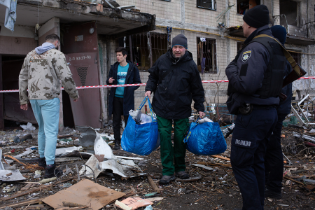 The residents leave their house which got shelled on March 14, 2022, in Obolon district of Kyiv, Ukraine. Russian forces continue to attempt to encircle the Ukrainian capital, although they have faced stiff resistance and logistical challenges since launching a large-scale invasion of Ukraine last month. Russian troops are advancing from the northwest and northeast of the city. (Photo by Anastasia Vlasova/Getty Images)