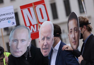 Protesters dressed as Russian President Vladimir Putin (L), U.S. President Joe Biden (C) and Ukrainian President Volodymyr Zelensky attend a small rally to demand a diplomatic solution to the current threat of war in Ukraine on February 09, 2022 in Berlin, Germany. Russia has amassed thousands of troops along its border to Ukraine, causing international fears of a possibly imminent military invasion.