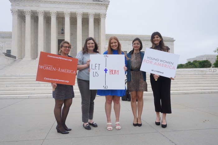 Demonstrators gathered with signs outside the U.S. Supreme Court in Washington, D.C. in support of football coach Joe Kennedy, who lost his job after kneeling on the field pray. Kennedy's case was heard by the high court on Monday, April 25, 2022. 