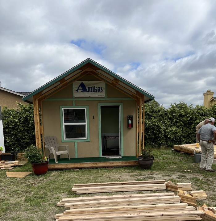 A cabin under construction with a sign on top that reads 'Amikas.'