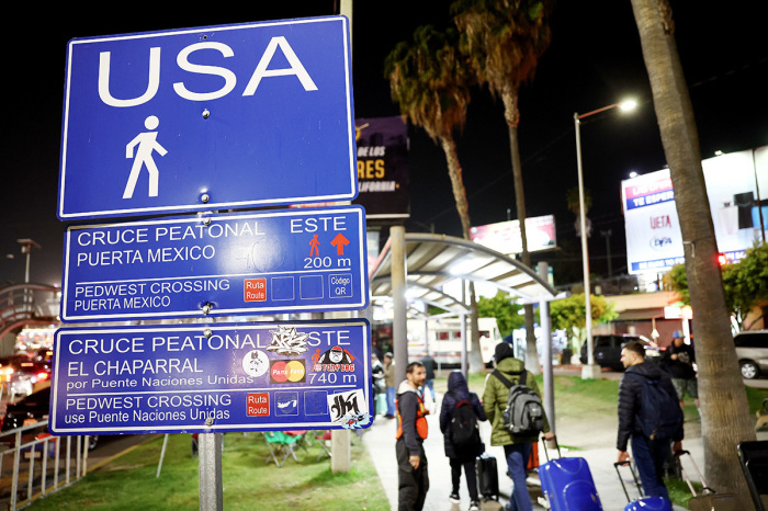 Ukrainians who are seeking asylum in the U.S. walk on their way to attempt to cross the U.S.-Mexico border at the San Ysidro Port of Entry, amid the Russian invasion of Ukraine, on April 5, 2022, in Tijuana, Mexico. U.S. authorities are allowing Ukrainian refugees to enter the U.S. at the Southern border in Tijuana with permission to remain in the country on humanitarian parole for one year.