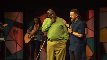 Walter Hooker (C), the senior associate pastor, of Bellevue Christian Center in Bellevue, Nebraska, weeps after revealing his lead pastor, Andy Kaup (R), will donate a life-saving kidney to him on Aug. 2. 2022.