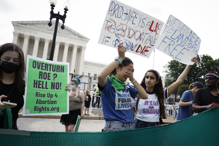 Abortion-rights activists Carrie McDonald (C) and Soraya Bata react to the Dobbs v. Jackson Women's Health Organization ruling in front of the U.S. Supreme Court on June 24, 2022, in Washington, D.C. The Court's decision in Dobbs v. Jackson Women's Health overturns the nearly 50-year-old Roe v. Wade case and returns abortion laws to the states. 