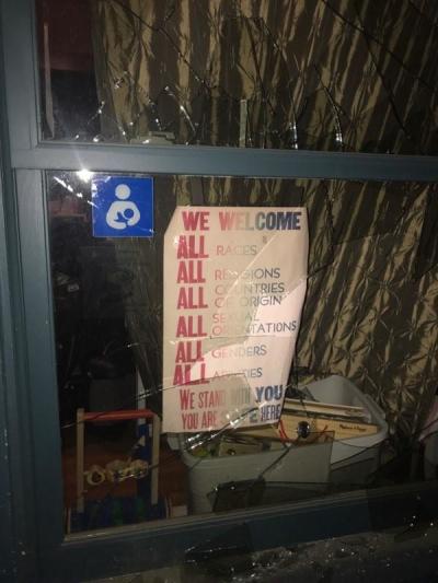 A 'We Welcome All' sign was covered in broken glass during the rioting. 