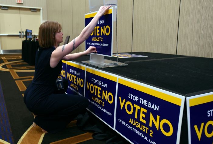 Field organizer Jae Grey places signs on the podium before the pro-choice Kansas for Constitutional Freedom primary election watch party in Overland Park, Kansas, August 2, 2022. - Voters headed to the polls in the Midwestern US state of Kansas Tuesday to weigh in on the first major ballot on abortion since the Supreme Court ended the national right to the procedure in June. 