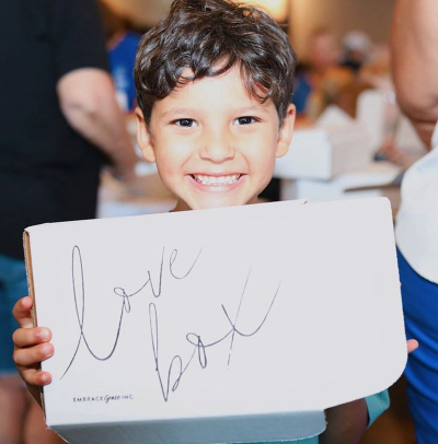 Mateo Martinez, whose mother Maddie works as the groups coordinator for the pro-life group Embrace Grace, holds one of the organization's signature 'Love Boxes' that it provides to mothers facing unplanned pregnancies.