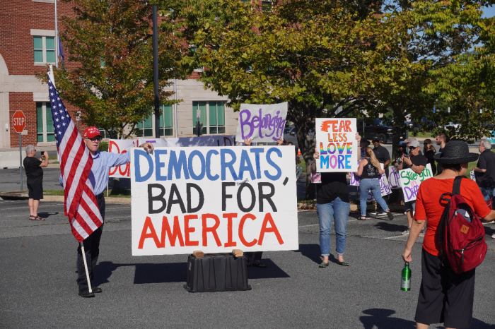 Protesters and counterprotesters hold signs during a rally outside the Loudoun County Public Schools headquarters in Broadlands, Virginia, on Sept. 13, 2022.