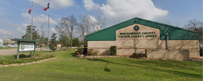 Flags fly outside of the headquarters for Montgomery County Justice of the Peace Precinct 1 in Willis, Texas. 