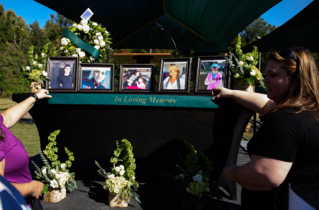 People set up a memorial table with images of the victims of a shooting in the Hedignham neighborhood on October 15, 2022, in Raleigh, North Carolina. A vigil to honor victims and to offer healing through counselors and other community resources was held at the Willow Oak Pool after a 15 year old male shot and killed five people in the neighborhood and surrounding areas. 