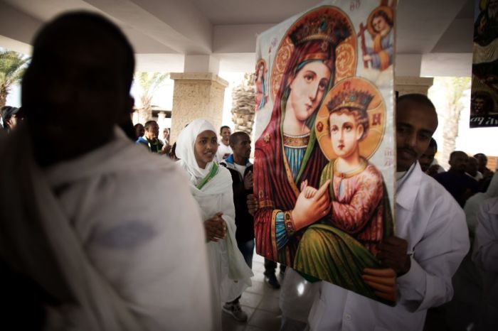 Members of the Eritrean and Ethiopian Christian Orthodox community from Tel Aviv are dancing before a baptism ceremony in the waters of the Jordan River as part of the Epiphany celebrations at the Qasr al-Yahud baptismal site, located on the border between Israeli control areas and Jordan near the West Bank city of Jericho on January 19, 2016.