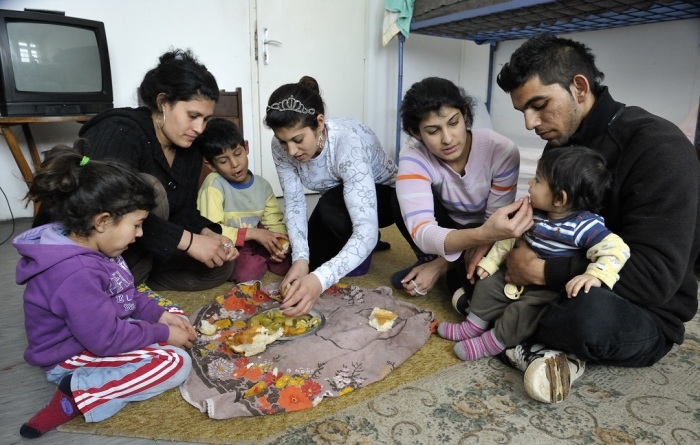 A Roma family displaced by a severe cold spell eats a meal in their temporary shelter at the Red Cross in Smederevo, Serbia, where they receive food and other emergency supplies from CWS.