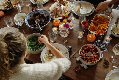 A girl eats while sitting at dining table during Thanksgiving. 