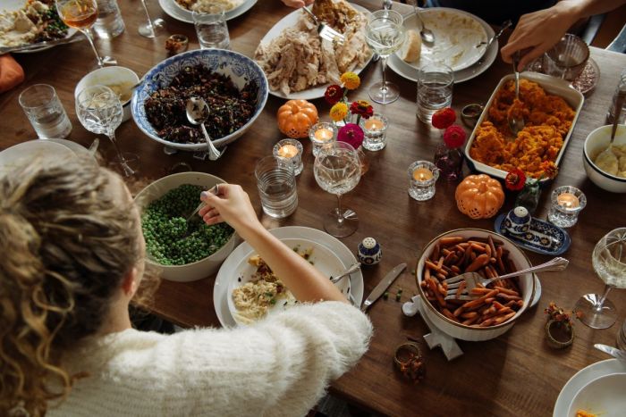 A girl eats while sitting at the dining table during Thanksgiving. 