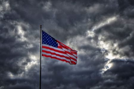 American flag flapping in dark ominous sky