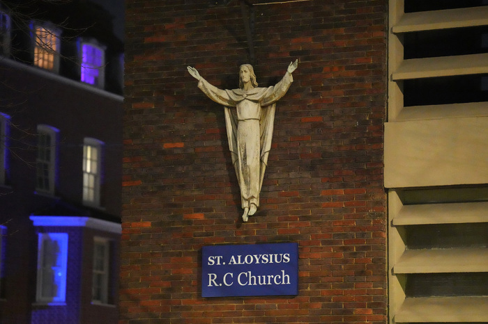 Police officers attend the scene of a shooting by St Aloysius R.C. Church on January 14, 2023, in London, England. Police responded to reports shots were fired from a moving vehicle, during a funeral at St Aloysius R.C. Church, in Euston, leaving three women and a seven-year-old injured.