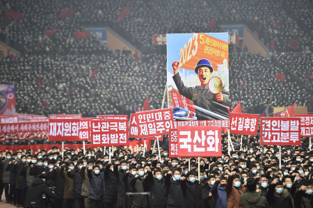 In this photo taken on January 5, 2023, people hold placards including one (top) that translates as 2023 - Key year of five-year plan implementation during a rally to vow to carry through the decisions of the 6th Plenary Meeting of the 8th Central Committee of the Workers' Party of Korea (WPK) at the Mayday Stadium in Pyongyang.