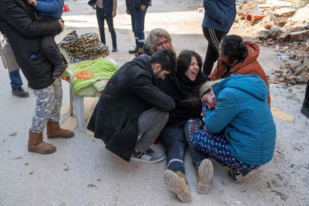 People react in mourning next to the rubble of collapsed buildings in Hatay, southeastern Turkey, on February 8, 2023, two days after a strong earthquake struck the region. - Searchers were still pulling survivors on February 8 from the rubble of the earthquake that killed over 11,200 people in Turkey and Syria, even as the window for rescues narrowed. For two days and nights since the 7.8 magnitude quake, thousands of searchers have worked in freezing temperatures to find those still alive under flattened buildings on either side of the border. 