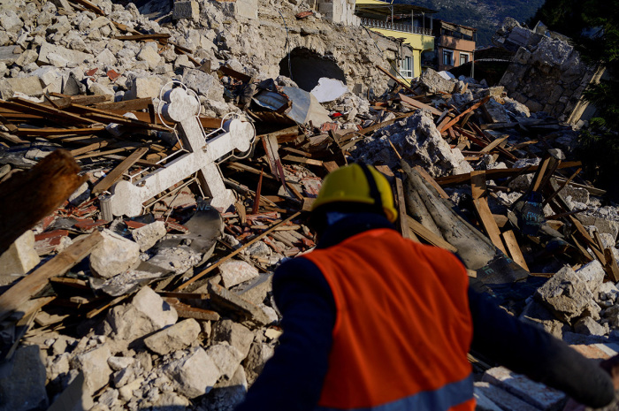 Sertac Paul Bozkurt, local Christian worshipper of the Antioch Orthodox Church walk near the destroyed Greek Orthodox Church in the historic southern city of Antakya on February 12, 2023, after a 7.8 magnitude earthquake struck the border region of Turkey and Syria earlier in the week. 