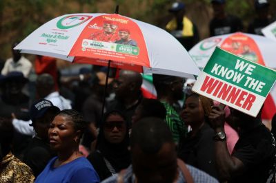 Supporters of Nigeria's Peoples Democratic Party carry a placard during a protest at Independent National Electoral Commission (INEC) headquarters, over the results of Nigeria's 2023 presidential and general election in Abuja on March 6, 2023. 