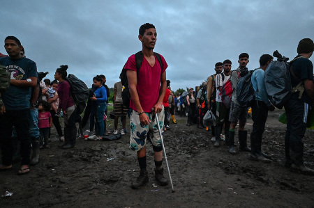 Venezuelan and Haitian migrants wait to be registered at Canaan Membrillo village, the first border control of the Darien Province in Panama, on October 13, 2022. - The clandestine journey through the Darien Gap usually lasts five or six days at the mercy of all kinds of bad weather: snakes, swamps and drug traffickers who use these routes to take cocaine to Central America.