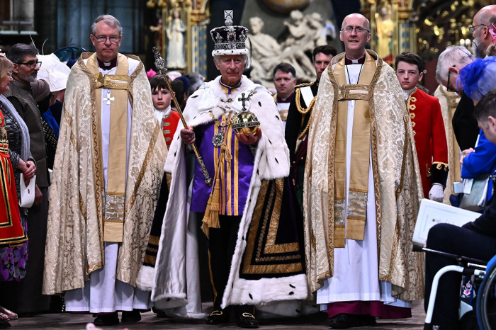 Britain's King Charles III wearing the Imperial state Crown carrying the Sovereign's Orb and Sceptre leaves Westminster Abbey after the Coronation Ceremonies in central London on May 6, 2023. - The set-piece coronation is the first in Britain in 70 years, and only the second in history to be televised. Charles will be the 40th reigning monarch to be crowned at the central London church since King William I in 1066. Outside the U.K., he is also king of 14 other Commonwealth countries, including Australia, Canada and New Zealand. 