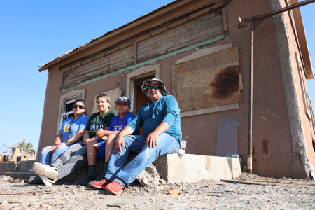 The Uribe family sits on the stoop outside their residence in Perryton, Texas, after a tornado devastated the town on June 15, 2023. 