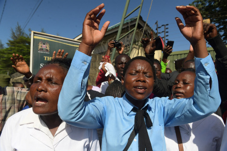 Members and worshipers of the New Life Prayer Centre and Church sing and pray before the beginning of court case against televangelist Ezekiel Odero on suspicion of murder, aiding suicide, abduction, radicalisation, crimes against humanity, child cruelty, fraud and money laundering, at the Shanzu law courts, Mombasa on May 4, 2023. - Ezekiel Odero, a wealthy televangelist who boasts a huge following, is being investigated on a raft of charges, including murder, aiding suicide, abduction, radicalisation, crimes against humanity, child cruelty, fraud and money laundering. Prosecutors accuse Odero of links to cult leader Paul Nthenge Mackenzie, who is in custody facing terrorism charges over the deaths of more than 100 people, many of them children. 