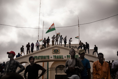 Protesters hold a Niger flag during a demonstration on independence day in Niamey on August 3, 2023. Hundreds of people backing the coup in Niger gathered for a mass rally in the capital Niamey with some brandishing giant Russian flags. The demonstrators converged at Concertation Square in the heart of the city, following a call by a coalition of civil society associations on a day marking the country's 1960 independence from France. 