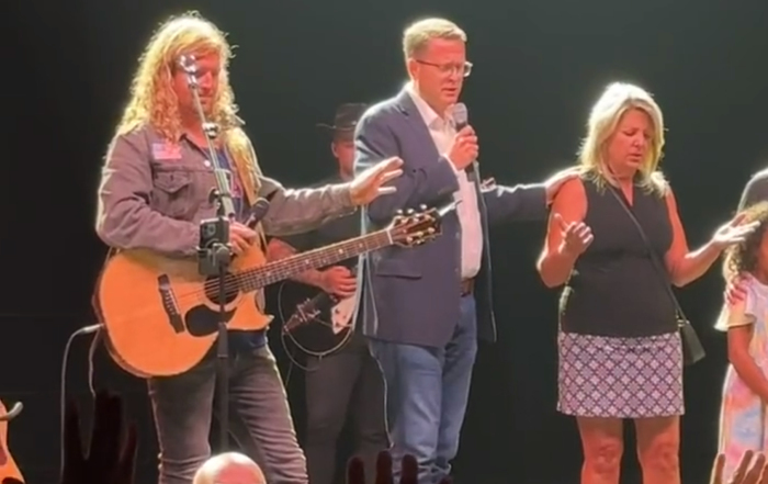 Spokane Mayor Nadine Woodward (R) receives prayer from Pastor Matt Shea (C) of On Fire Ministries, as Sean Feucht, a conservative musician and activist, prays along during a 'Let Us Worship' event in the city on August 20, 2023. 