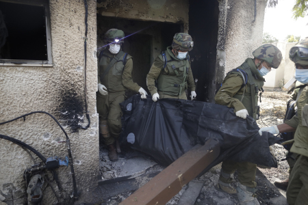 Israeli soldiers remove the body of a civilian, who was killed days earlier in an attack by Palestinian militants on this kibbutz near the border with Gaza, on October 10, 2023, in Kfar Aza, Israel. Israel has sealed off Gaza and conducted airstrikes on Palestinian territory after Hamas' attack killed hundreds and took nearly 100 hostages. On October 7, the Palestinian militant group Hamas launched a surprise attack on Israel from Gaza by land, sea and air, killing over 900 people and wounding more than 2,000. Israeli soldiers and civilians have also been taken hostage by Hamas and moved into Gaza. The attack prompted a declaration of war by Israeli Prime Minister Benjamin Netanyahu, and ongoing retaliatory strikes by Israel on Gaza killing hundreds. 