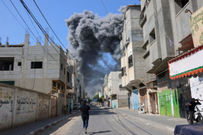 Smoke billows behind buildings after after an Israeli air strike in Rafah in the southern Gaza Strip on October 11, 2023. Israel declared war on Hamas on October 8 following a shock land, air and sea assault by the Gaza-based Islamists. The death toll from the shock cross-border assault by Hamas militants rose to 1,200, making it the deadliest attack in the country's 75-year history, while Gaza officials reported more than 1,000 people killed as Israel pounded the territory with air strikes. 