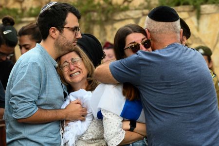 The mother, and immediate family of Valentin (Eli) Ghnassia, 23, who was killed in a battle with Hamas militants at kibbutz Be'eeri near the Israeli border with the Gaza Strip, grieve during his funeral on October 12, 2023, at Mount Herzl Military Cemetery in Jerusalem, Israel. Israel has sealed off Gaza and launched sustained retaliatory air strikes, which have killed at least 1,200 people with more than 300,000 displaced, after a large-scale attack by Hamas. On October 7, the Palestinian militant group Hamas launched a surprise attack on Israel from Gaza by land, sea and air, killing over 1,200 people and wounding around 2800. Israeli soldiers and civilians have also been taken hostage by Hamas and moved into Gaza. The attack prompted a declaration of war by Israeli Prime Minister Benjamin Netanyahu and the announcement of an emergency wartime government. 