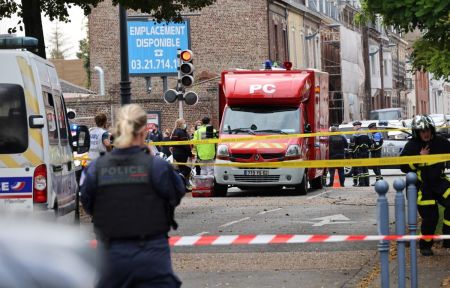 Emergency responders including firefighters and medical workers stand next to their vehicles parked near the Gambetta high school in Arras, northeastern France on Oct. 13, 2023, after a teacher was killed and two other people severely wounded in a knife attack. A man of Chechen origin stabbed to death a teacher and severely wounded two other adults on Oct.13 at a school in northeastern France, with prosectors opening a probe into a suspected act of terror. 