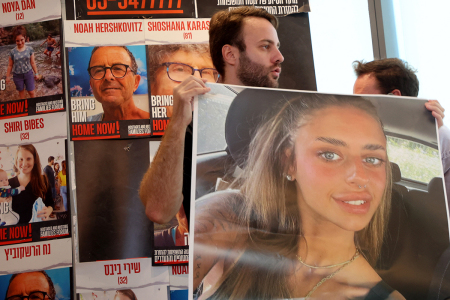 A man holds the image of French-Israeli woman Mia Shem, held hostage by Hamas terrorists in Gaza, before being attached to a window prior to her mother's arrival to give a press in Tel Aviv on October 17, 2023, amid the ongoing battles between Israel and the Palestinian terrorist group Hamas. The mother of French-Israeli woman Mia Shem, held hostage by Hamas in Gaza, urged world leaders on October 17, to free her daughter after the Islamists aired a video showing her in captivity. The Israeli military on October 16, raised the figure to 199 people confirmed to have been abducted by Hamas to the Gaza Strip in the militants' cross-border attacks on October 7 which sparked a devastating war. 