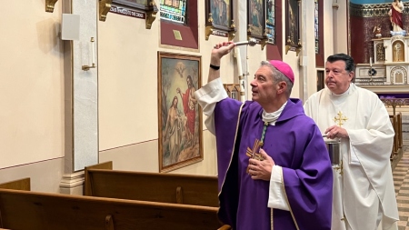 Bishop Robert Brennan is assisted by Monsignor Joseph Grimaldi, vicar general of the Diocese of Brooklyn, in blessing Annunciation Church with holy water in Brooklyn, New York, on November 4, 2023.