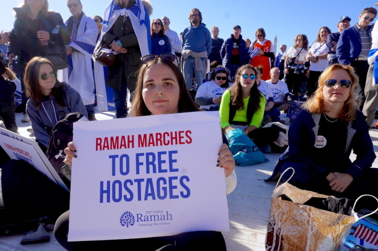 A demonstrator at the Americans March for Israel event sits holding a poster among other demonstrators in support of Israel in Washington, D.C., on November 14, 2023. 