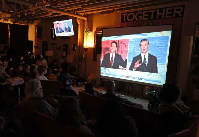 People watch a debate between California Gov. Gavin Newsom and Florida Gov. Ron DeSantis during a watch party at Manny's on Nov. 30, 2023, in San Francisco, California. 